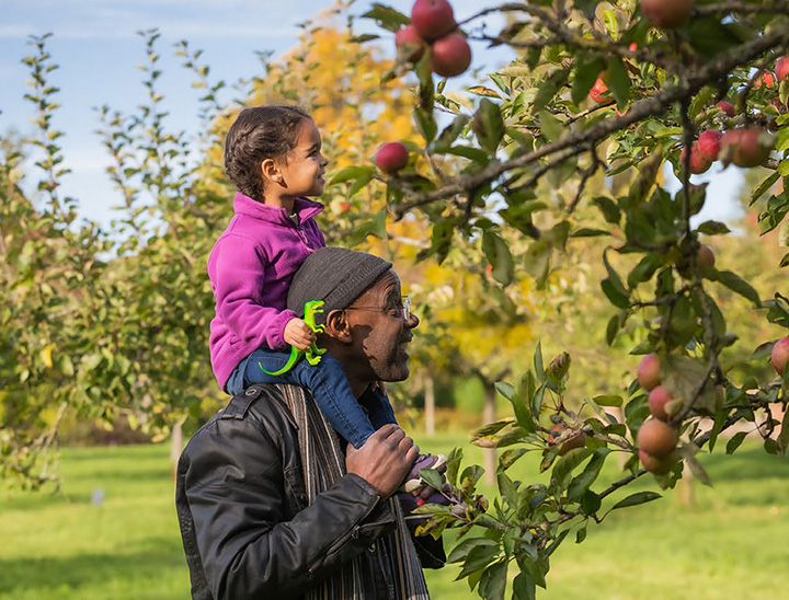 Image of child and parent in a green outdoor setting.