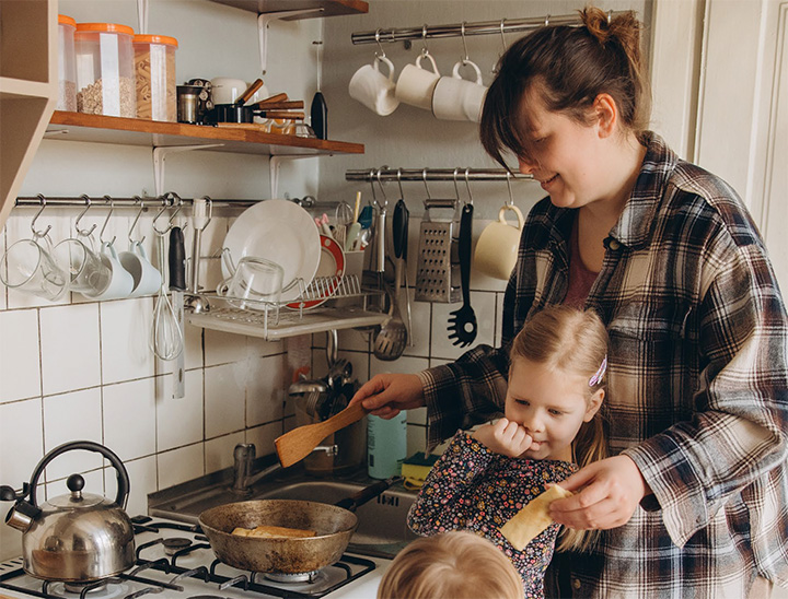A parent preparing a meal for their children