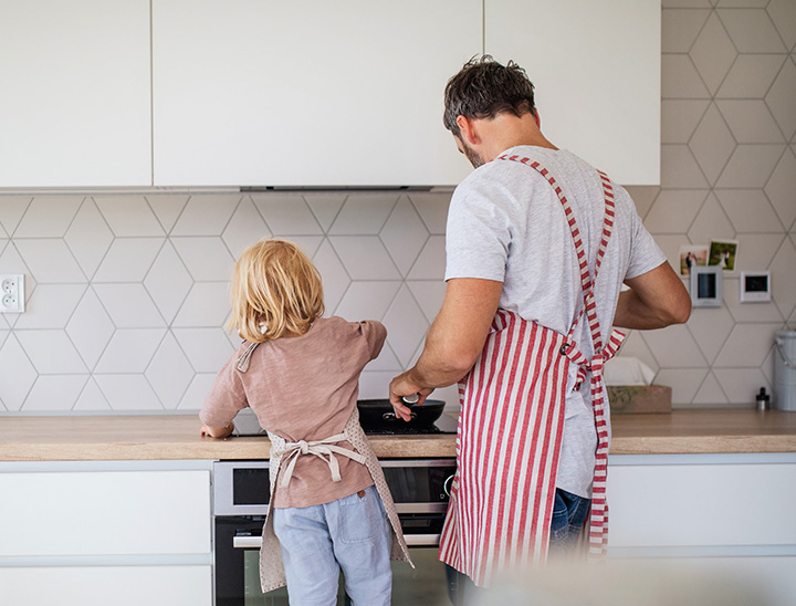 Parent and child cooking a meal together